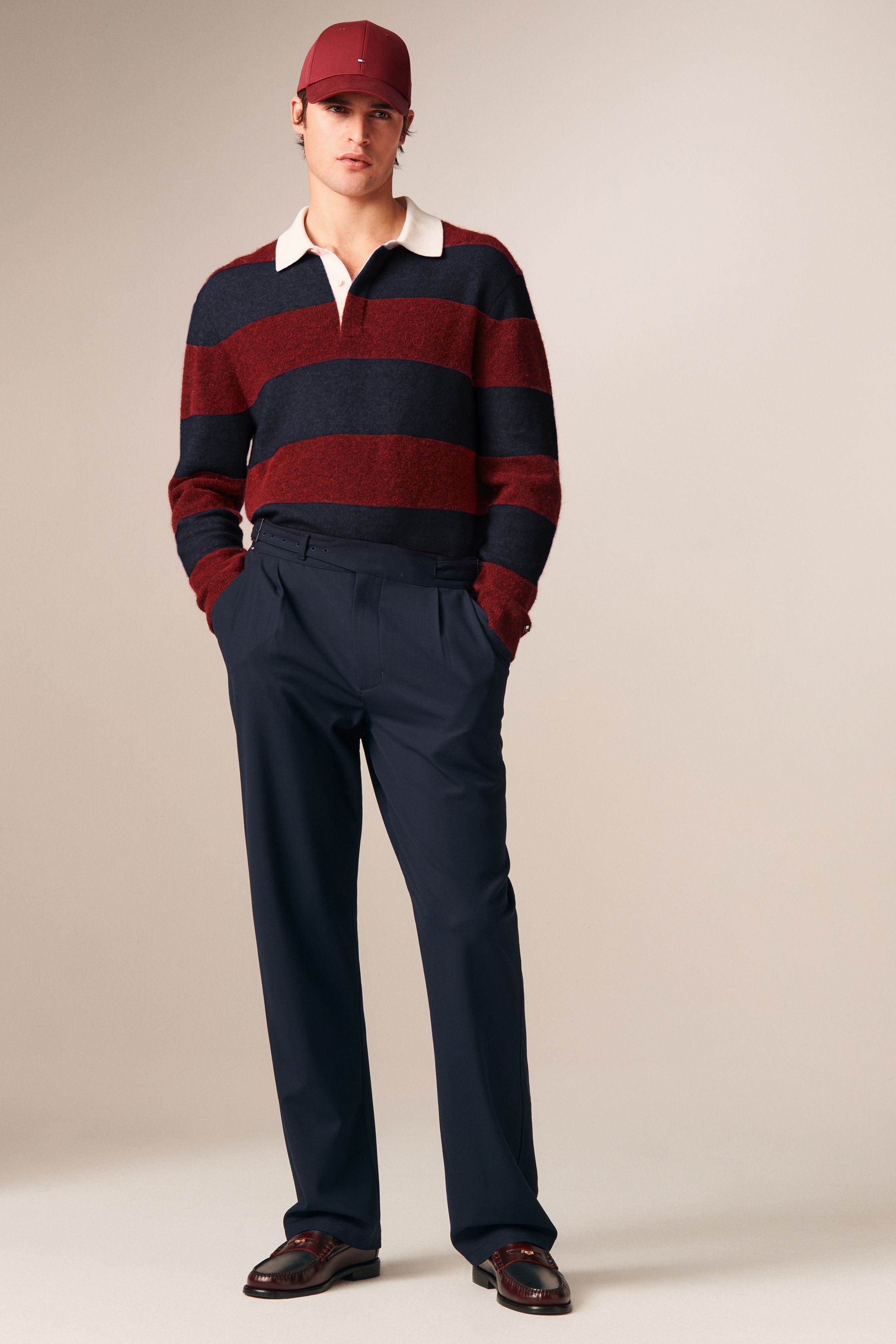 Tommy Hilfiger 26FW 男装回到品牌最擅长的美式学院与都市绅士语境。条纹针织、飞行夹克、羊羔毛外套与双排扣大衣共同勾勒出成熟却不老派的美式精英形象。色彩以海军蓝、酒红、驼色为核心，强化可靠、易穿的商业属性。系列不追求先锋表达，而是精准回应全球市场对“经典升级版”的现实需求-顽石频道趋势研究